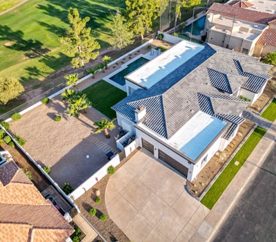 Aerial view highlights the pool, patio, and green lawn, showcasing the home s outdoor living and entertaining spaces.