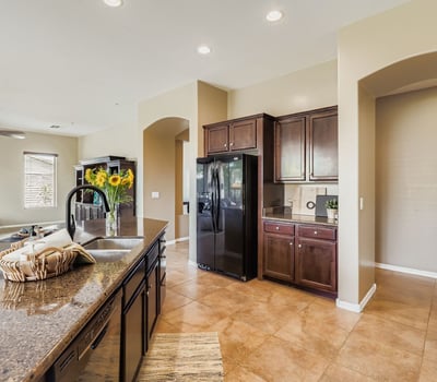 The kitchen features granite counters, rich wood cabinetry, and a functional island ideal for preparing meals or entertaining in Peoria.