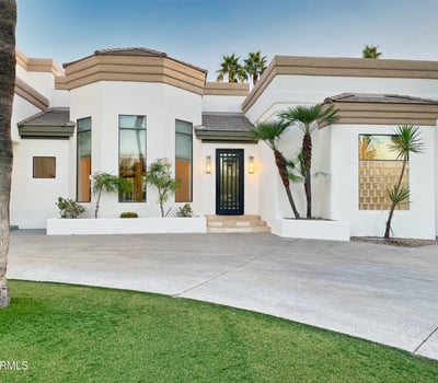 Striking entryway with tall windows, modern iron door, and smooth stucco finish for a sophisticated curb presence.