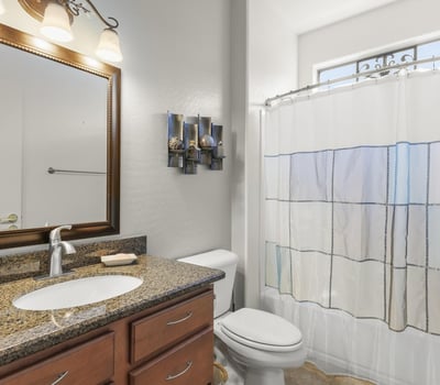 Granite counters, updated fixtures, and a framed mirror add a touch of elegance to this functional, modern guest bath.
