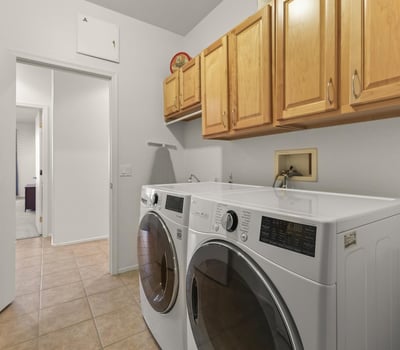Efficient laundry room featuring full-size LG washer and dryer, cabinetry for storage, and bright, easy-care finishes.