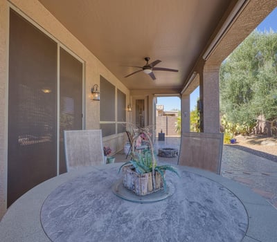Shaded patio with ceiling fan comfort and lush landscaping backdrop. A perfect place to unwind and savor Arizona s year-round sunshine.