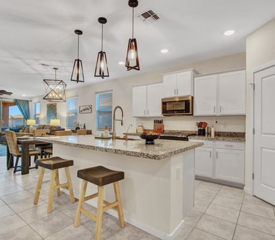The spacious kitchen boasts a large island, granite countertops, white cabinetry, and energy-efficient appliances. An ideal gathering spot in this beautifully updated Litchfield Park home.