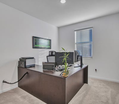 Natural light fills this front bedroom, offering a peaceful setting for guests or work. The room s clean lines and soft carpet complement the home s Litchfield Park charm.