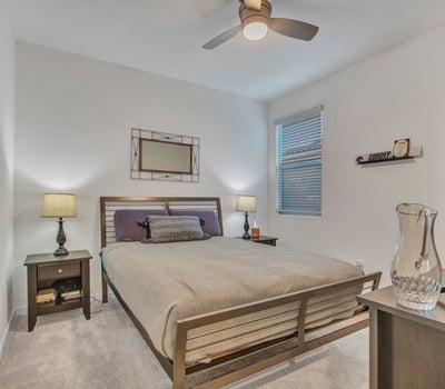 A peaceful guest retreat with warm lighting, neutral tones, and plush carpet, offering comfort and privacy in this Litchfield Park home.
