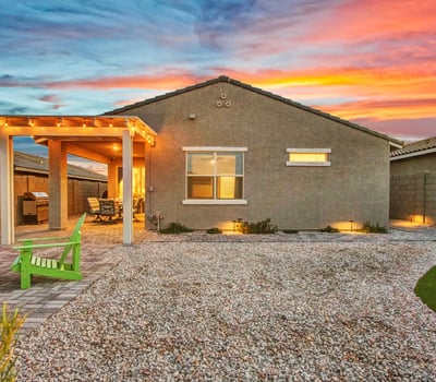 The backyard glows with warm lighting, updated landscaping, and a charming pergola, creating an inviting outdoor haven in Litchfield Park.