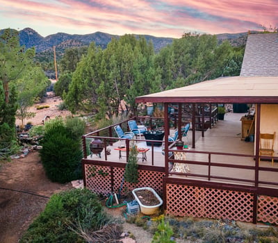 Relax on the spacious deck overlooking rolling Hackberry hills, mature pines, and painted sunsets. This outdoor oasis captures the property s serene mountain-view atmosphere.