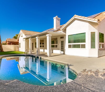 Inviting Scottsdale backyard featuring a sparkling swimming pool, covered patio, and spacious deck area ideal for outdoor gatherings. The private yard creates a relaxing retreat perfect for enjoying sunny Arizona days.