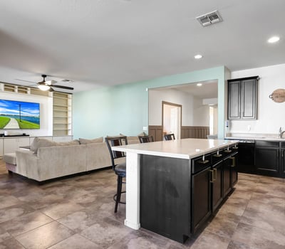 Open living space with tile flooring and built-in entertainment shelving, creating a comfortable central gathering area within this well-designed Tolleson home.