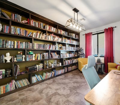 Versatile den featuring full wall built-in shelving and tile floors, ideal for working from home or personal hobbies.