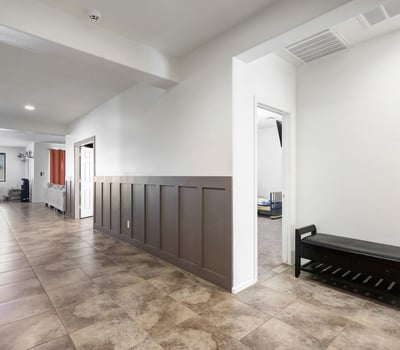 Entry corridor with a bold designer accent wall and tile flooring, creating a stylish first impression for guests.