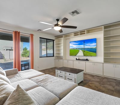 Open great room with built-in cabinetry, tile floors, and natural light, connecting indoor comfort with outdoor access.