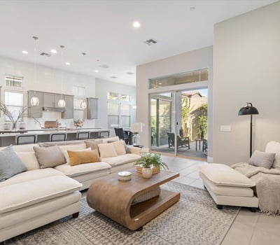 Open living room designed with comfort and flow in mind, featuring high ceilings, soft tones, and direct connection to the kitchen and dining spaces.
