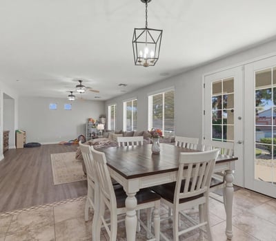 Dining area with elegant pendant lighting and French doors providing access to the backyard pool and outdoor living area.