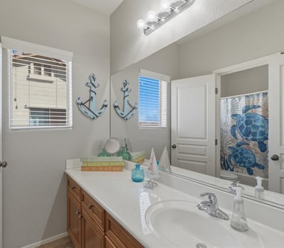 Clean and functional bathroom featuring a vanity with storage, large mirror, and shower tub combination designed for everyday convenience.