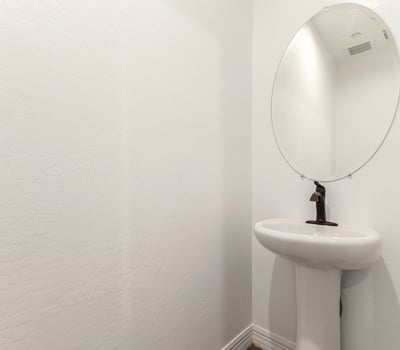 Clean and modern guest bathroom with pedestal sink and updated fixtures, offering convenience and style for visitors.
