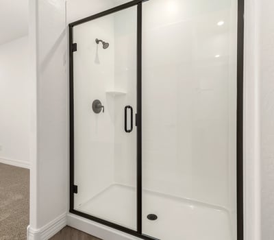 Walk-in shower with glass doors and contemporary fixtures, offering a clean and refreshed bathroom design.