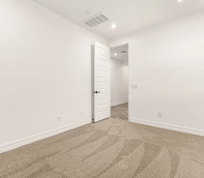 Bright bedroom featuring neutral finishes, soft carpet, and energy-efficient window coverings for a comfortable atmosphere.