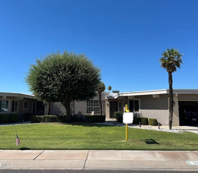 Attractive Sun City exterior featuring green lawn, shade trees, and inviting curb appeal that enhances the home's overall charm.