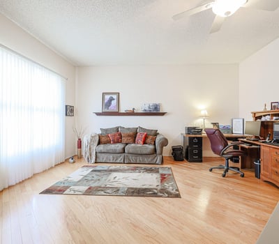 Spacious flex room perfect for a home office, hobby room, or additional living space with hardwood floors and bright windows.