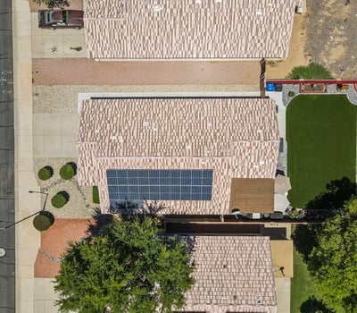 Top-down view displaying the home s footprint, solar system, and spacious backyard with turf and patio areas in Surprise.