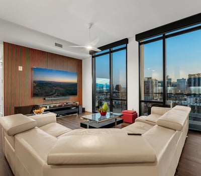 Open living area filled with natural light, featuring floor-to-ceiling windows and panoramic Phoenix views, perfect for modern indoor-outdoor living.