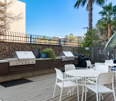 Outdoor BBQ area with multiple grills, seating, and modern finishes, creating a perfect gathering space in Phoenix.