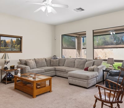 Bright living room with large windows, open layout, and comfortable design, ideal for both entertaining and relaxing in this Phoenix property.