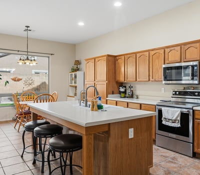 Well-designed kitchen with large island, breakfast seating, and generous cabinet storage, ideal for hosting and daily use in Phoenix.