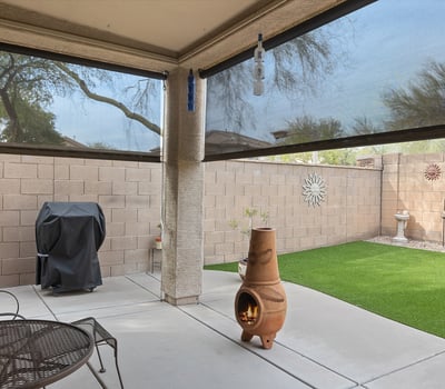 Backyard with artificial turf, covered patio, and low-maintenance design, ideal for outdoor relaxation and entertaining in Phoenix.