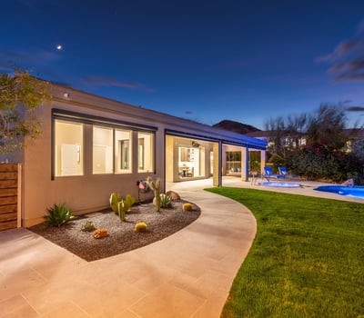 Bright covered patio opening to a lush backyard with pool and landscaping, showcasing seamless Scottsdale indoor-outdoor living.