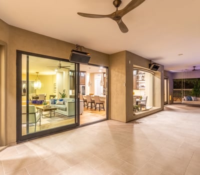 Expansive covered patio with tile flooring, ceiling fans, and sliding glass doors, creating a seamless transition between indoor comfort and Scottsdale outdoor living.
