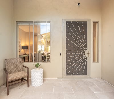 Covered Scottsdale front patio with seating area and decorative security door, offering charm and privacy.