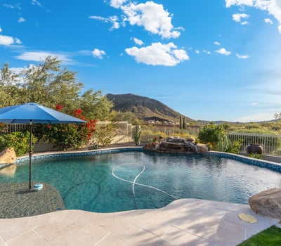 Scottsdale backyard with custom pool, rock water feature, and mountain views, creating a relaxing and private outdoor space.