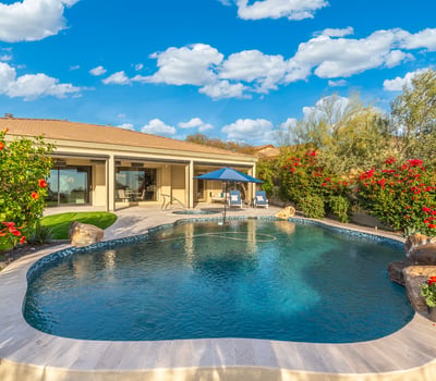 Scottsdale outdoor living area with pool, covered patio, and landscaped yard, offering comfortable indoor-outdoor flow.