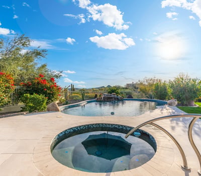 Scottsdale backyard with pool, spa, and lounge seating, surrounded by desert landscaping and designed for outdoor living.