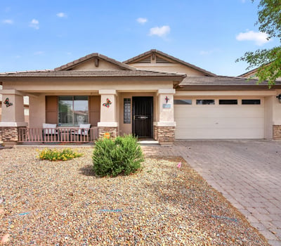 Attractive exterior with covered porch, desert landscaping, and attached garage. Clean curb appeal defines this Casa Grande property.