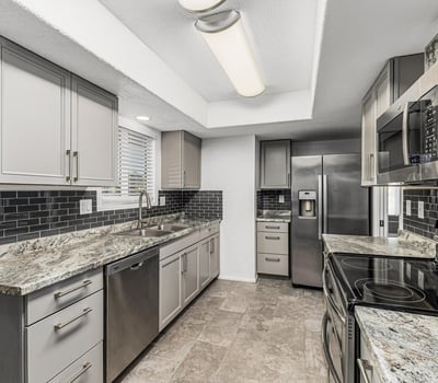 Kitchen with built-in storage, updated counters, and stainless steel appliances. This Sun City home highlights modern updates and organized space.