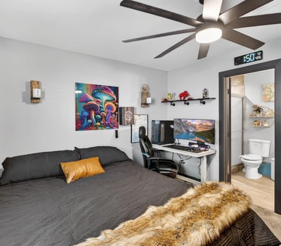 Versatile bedroom featuring workspace setup, ceiling fan, and modern finishes, ideal for both productivity and relaxation.