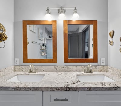 Stylish bathroom with dual sinks, granite counters, and updated lighting, designed for comfort and convenience.