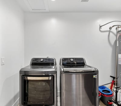 Functional laundry area with washer, dryer, and water heater, designed for efficiency and convenience in this Phoenix home.