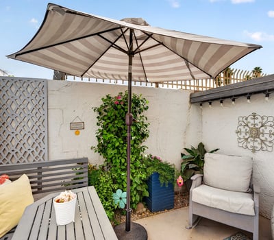 Relax in a private Scottsdale patio featuring shaded seating, decorative accents, and low-maintenance landscaping ideal for outdoor living and entertaining.