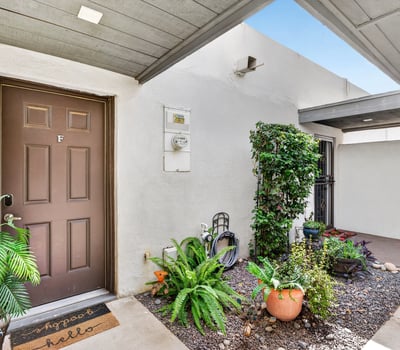 Covered front entry with desert landscaping and greenery creates a warm welcome to this Scottsdale townhome with added privacy and charm.
