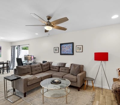 Light-filled Scottsdale living space with ceiling fan, updated flooring, and open-concept design that enhances comfort and functionality.