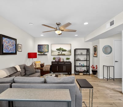 Inviting Scottsdale living space with staircase feature, updated flooring, and open flow connecting living, dining, and kitchen areas.