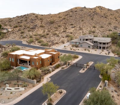 Secure gated entrance welcomes residents into an upscale hillside neighborhood surrounded by luxury custom homes and scenic desert landscapes near South Mountain Preserve.