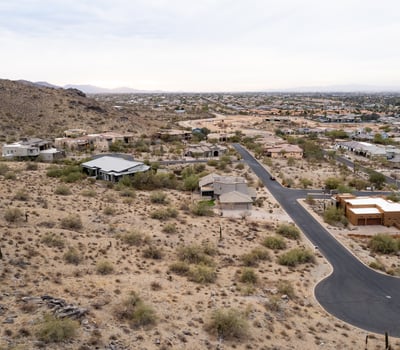 Exceptional aerial perspective showcasing the property s elevated setting among scenic desert terrain and luxury homes. Build your dream residence surrounded by breathtaking Phoenix mountain views.