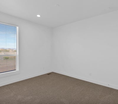 Light-filled bedroom with attractive finishes, large windows, and comfortable carpeting. Perfect for use as a guest room, family bedroom, hobby room, or home office.