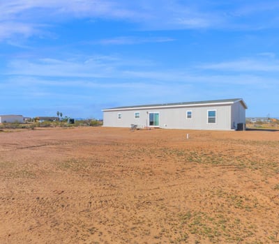 Rear view of the property highlighting the home's placement on a generous lot. The abundant outdoor space offers opportunities for landscaping, entertaining areas, and enjoying Wittmann's natural surroundings.