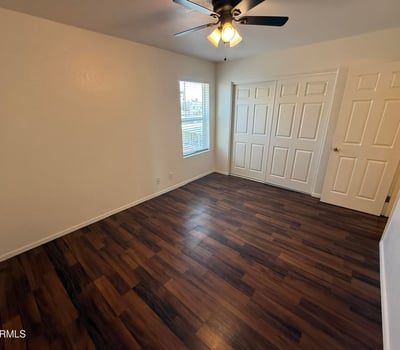 Spacious bedroom featuring a large closet, neutral finishes, and durable flooring. The room's generous proportions create a comfortable setting for a variety of furniture configurations.